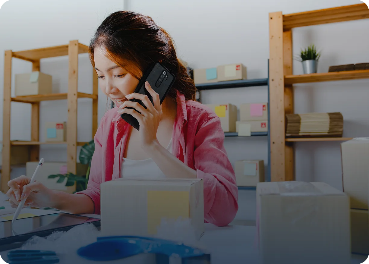 a woman talking on the phone while seated at her office desk
