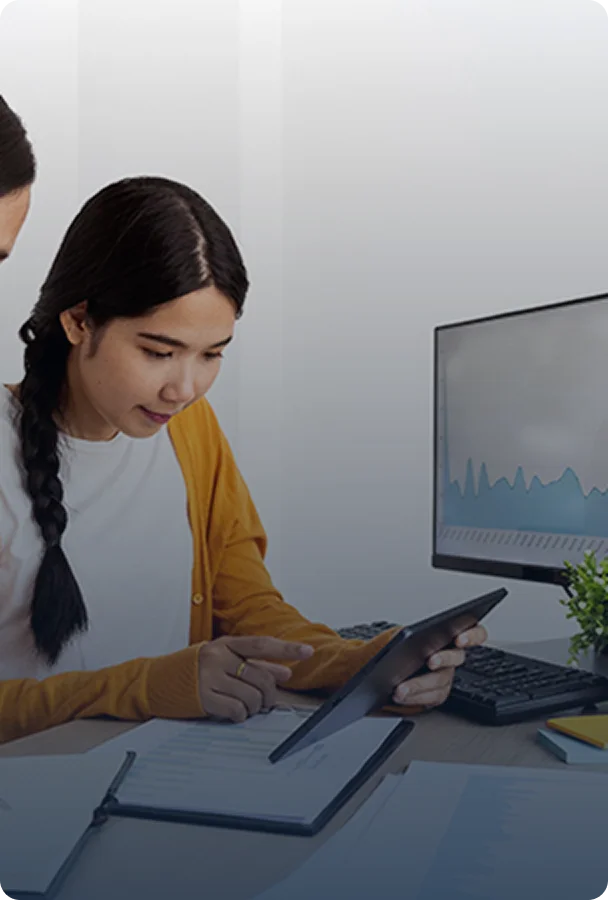 two women collaborating while looking at a computer screen